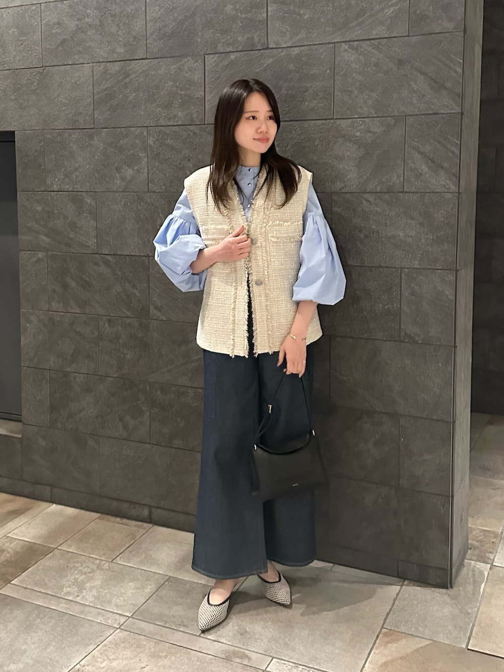 ブルー系のシャツ/ブラウス、ブルー系のデニムパンツ、ベージュ系のベストを着用したレディースの冬コーディネートの2枚目の写真