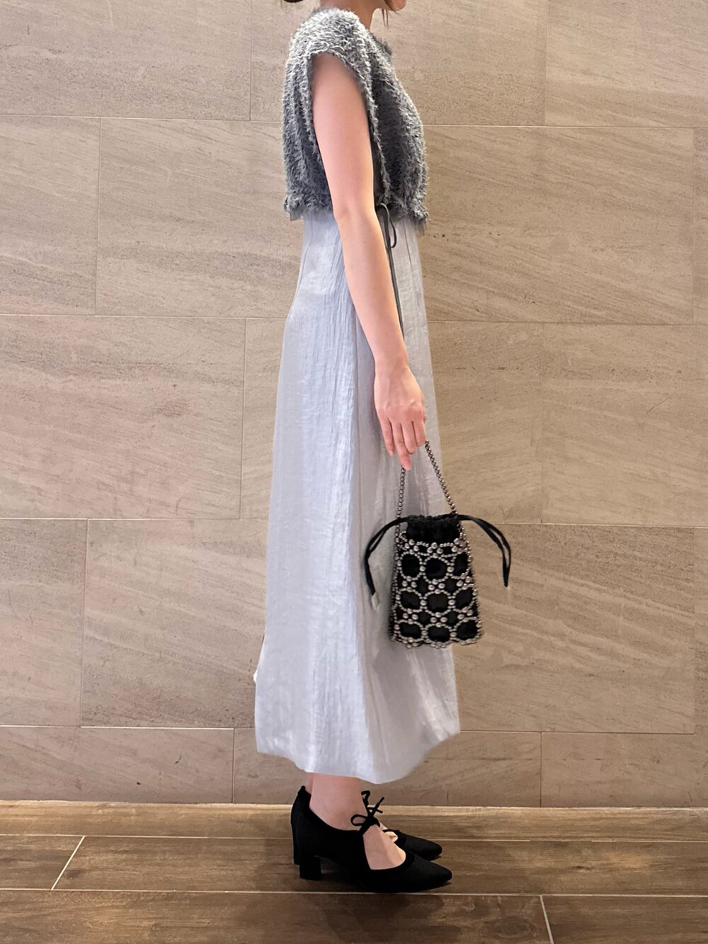 ブルー系のワンピース、ブラック系のハンドバッグ、ブラック系のパンプスを着用したレディースの夏コーディネートの4枚目の写真