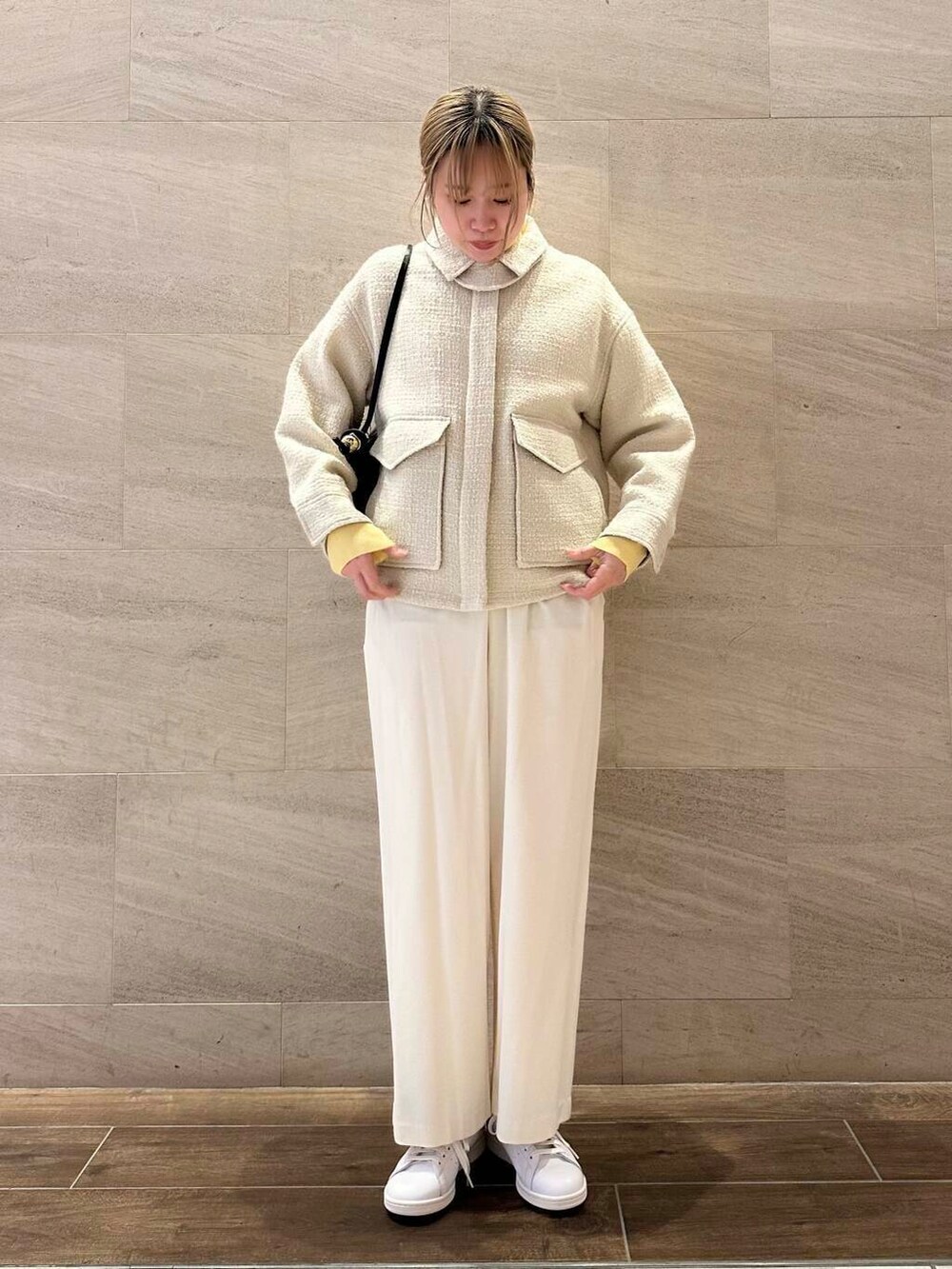 ホワイト系のスニーカー、ホワイト系のブルゾン、ブラック系のショルダーバッグを着用したレディースの冬コーディネートの3枚目の写真