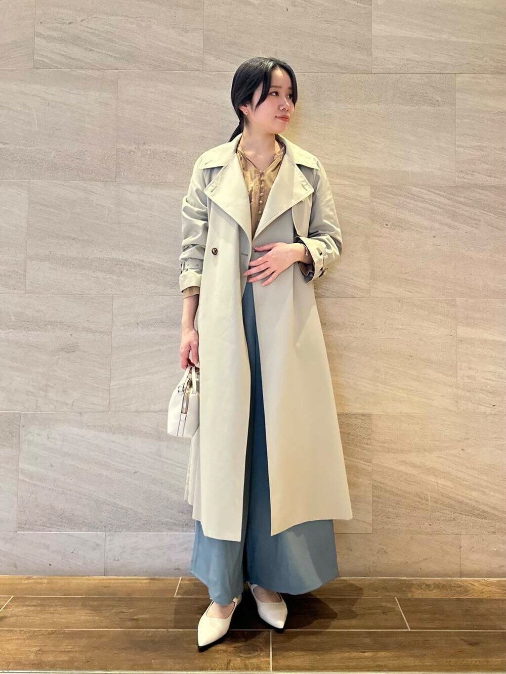 グレー系のトレンチコート、ブルー系のその他パンツ、イエロー系のシャツ/ブラウスを着用したレディースの春コーディネートの4枚目の写真