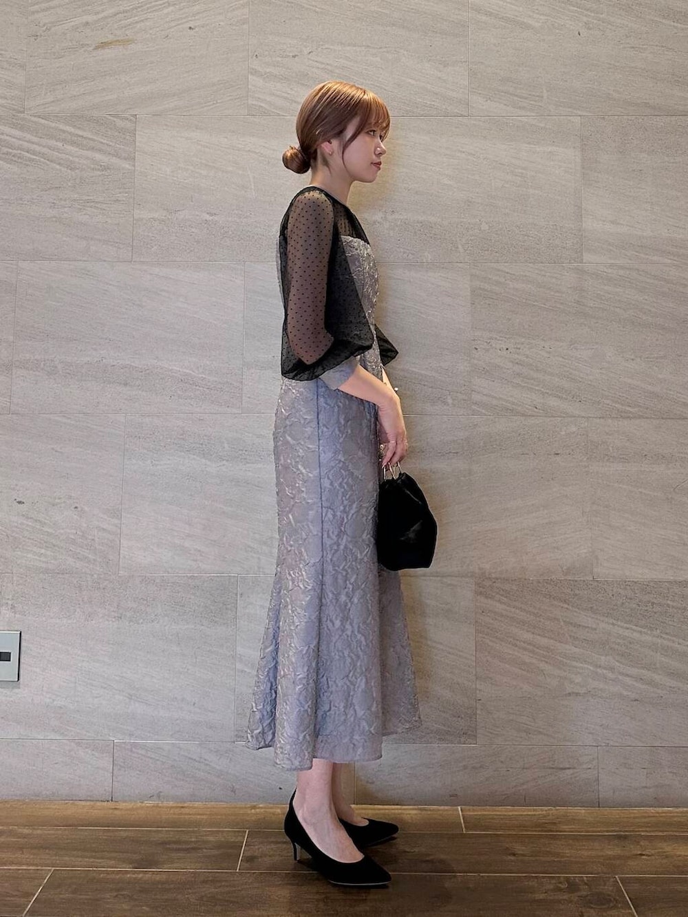 ブラック系のパンプス、ブラック系のハンドバッグ、グレー系のワンピースを着用したレディースの夏コーディネートの4枚目の写真