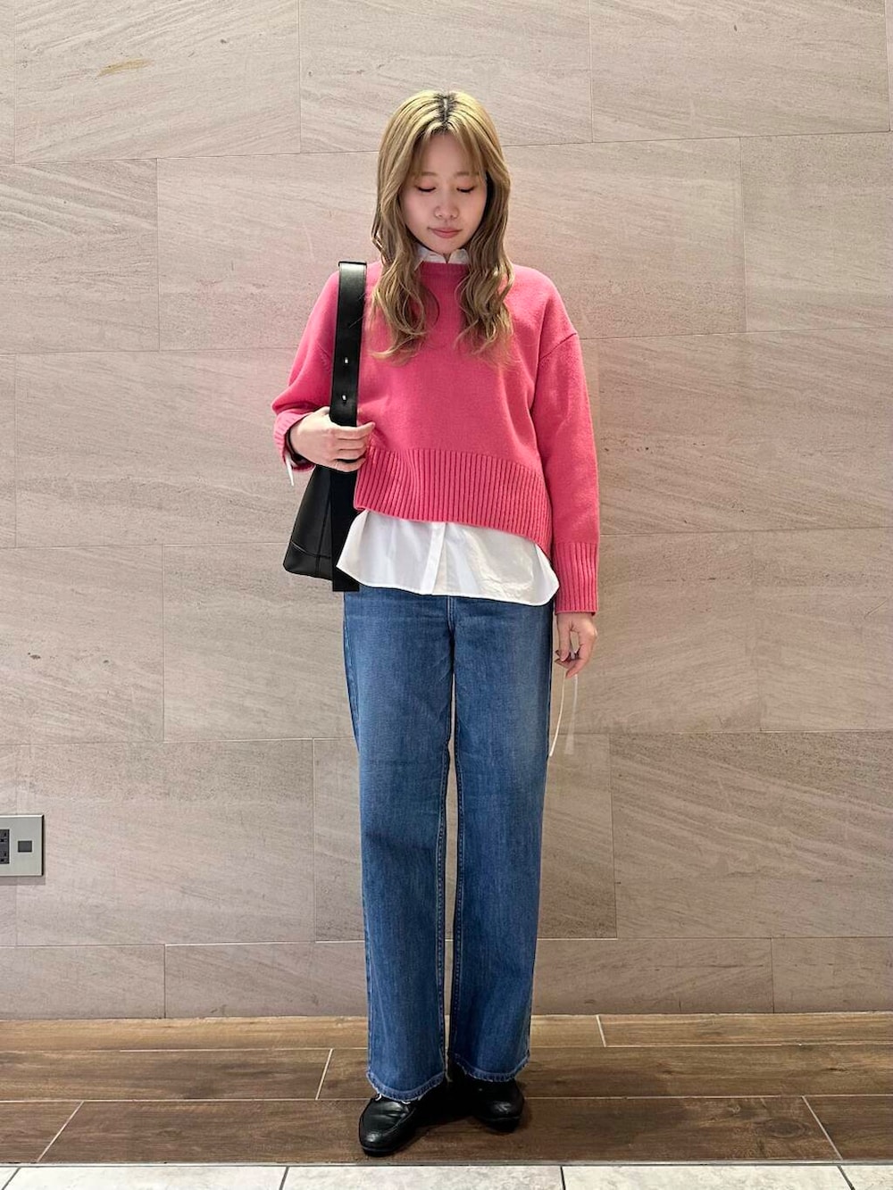 ピンク系のニット/セーター、ホワイト系のシャツ/ブラウス、ブラック系のショルダーバッグを着用したレディースの冬コーディネートの3枚目の写真