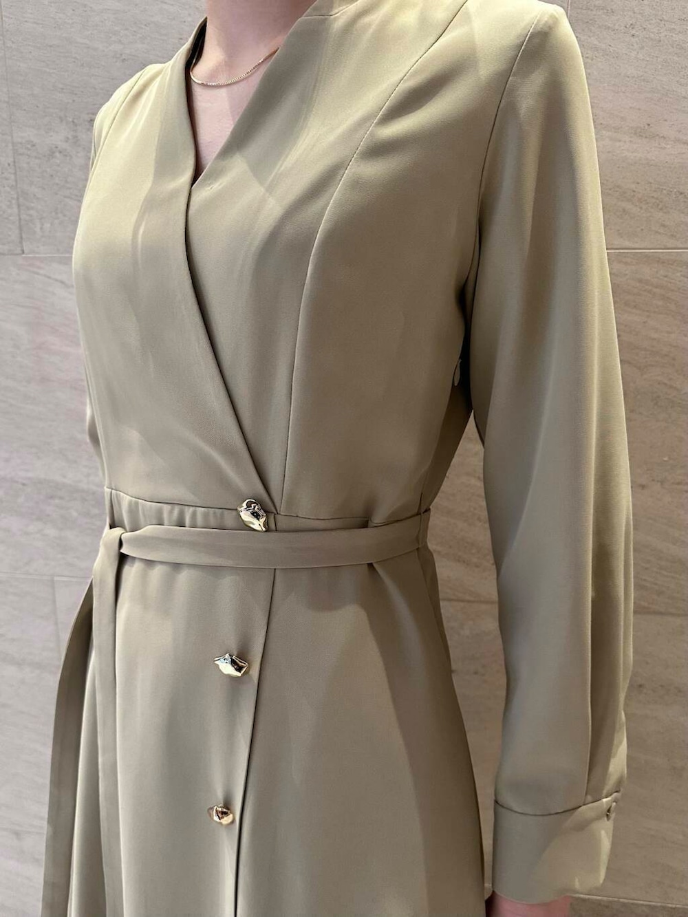 ブラウン系のパンプス、ブラック系のハンドバッグ、ベージュ系のワンピースを着用したレディースの冬コーディネートの6枚目の写真