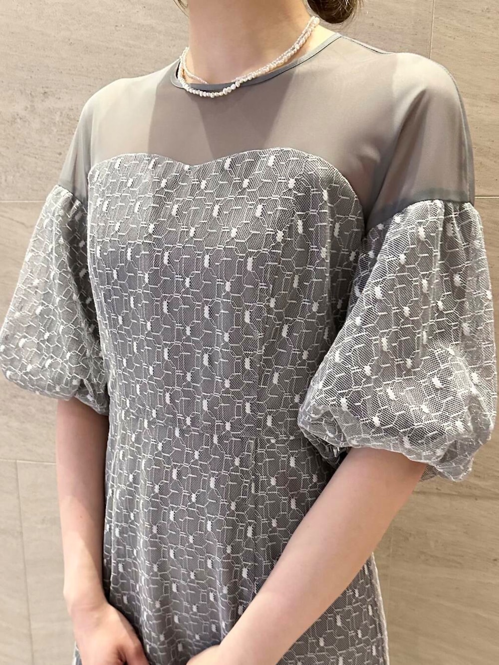 ブラウン系のパンプス、シルバー系のハンドバッグ、グレー系のワンピースを着用したレディースの春コーディネートの6枚目の写真