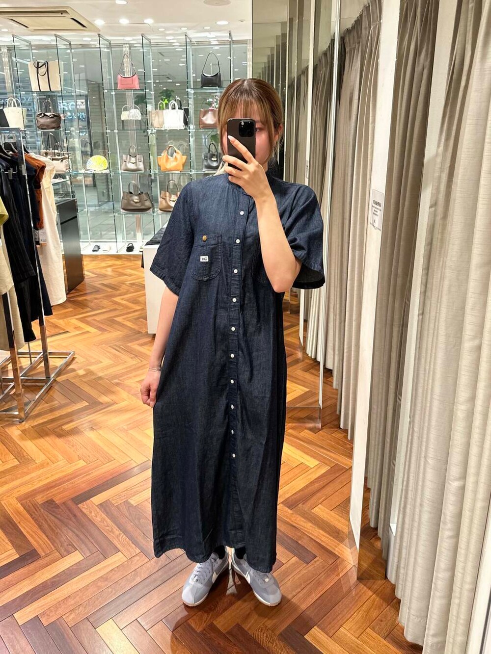 ブラウン系のかごバッグ、ブルー系のワンピース、グレー系のスニーカーを着用したレディースの夏コーディネートの4枚目の写真