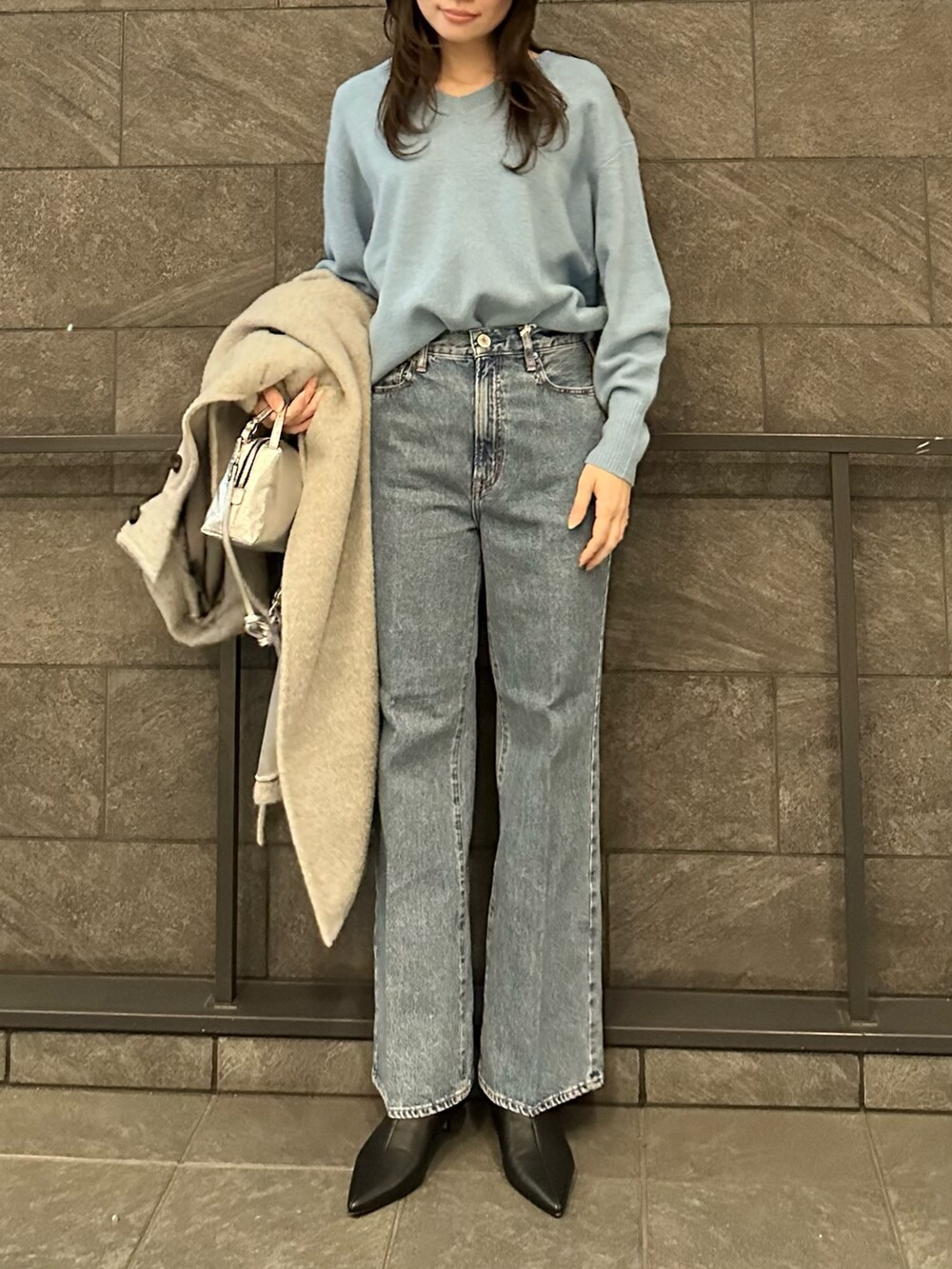 グレー系のその他アウター、ブルー系のニット/セーター、ブルー系のデニムパンツを着用したレディースの冬コーディネートの5枚目の写真