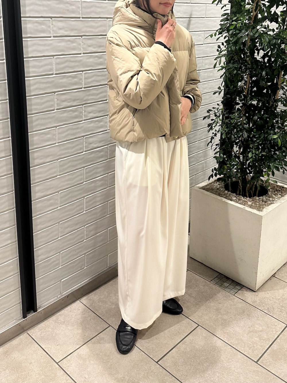 ベージュ系のダウンジャケット/コート、ホワイト系のニット/セーター、ホワイト系のその他パンツを着用したレディースの冬コーディネートの3枚目の写真