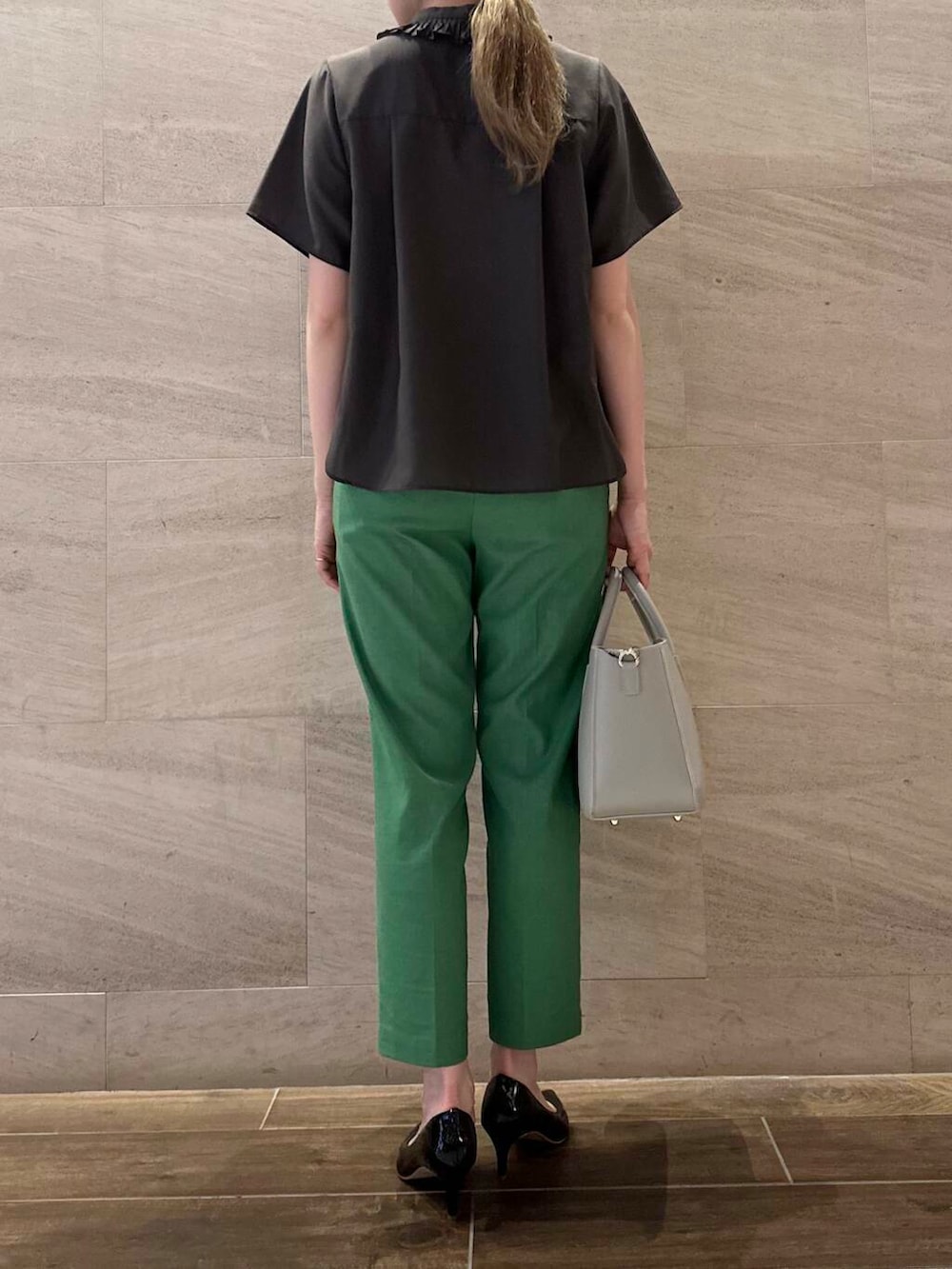ブラック系のパンプス、グレー系のハンドバッグ、グリーン系のその他パンツを着用したレディースの春コーディネートの4枚目の写真
