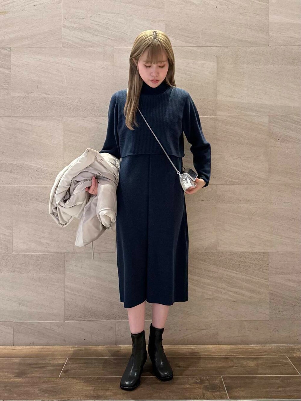 ブラック系のブーツ、ホワイト系のダウンジャケット/コート、ブルー系のワンピースを着用したレディースの冬コーディネートの7枚目の写真