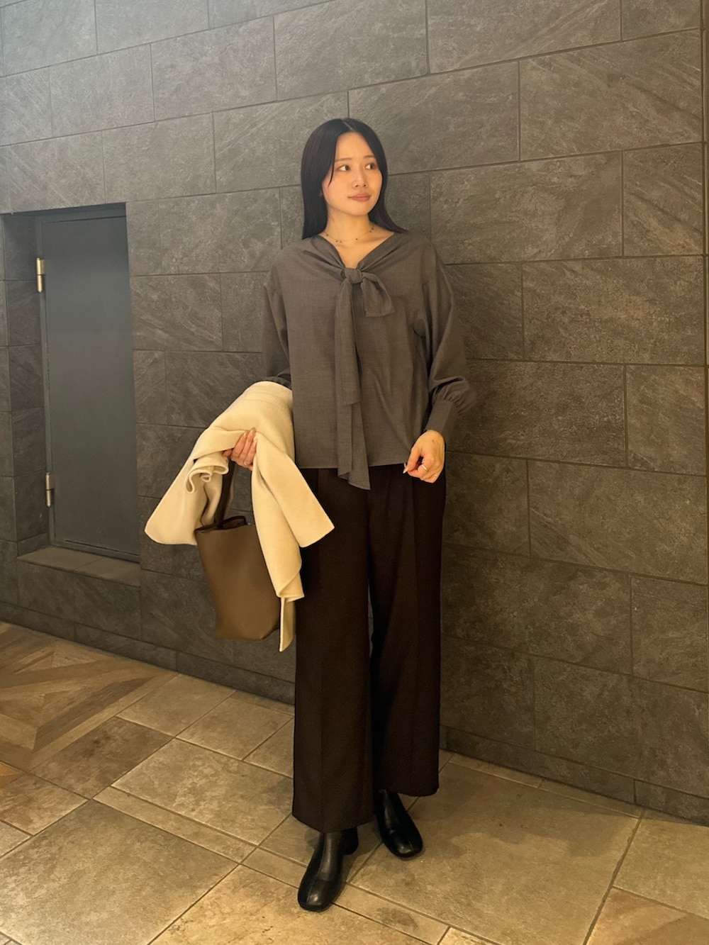 グレー系のシャツ/ブラウス、ブラウン系のその他パンツ、ブラック系のブーツを着用したレディースの秋コーディネートの7枚目の写真