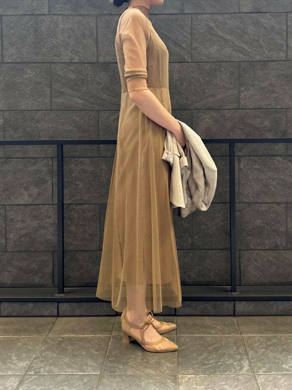 ゴールド系のワンピース、ベージュ系のハンドバッグ、ベージュ系のその他アウターを着用したレディースの夏コーディネートの5枚目の写真