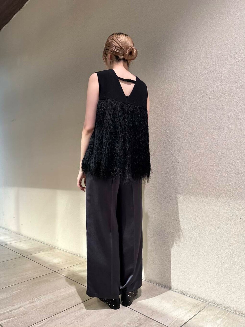 ホワイト系のショルダーバッグ、ブラック系のパンプス、グレー系のその他パンツを着用したレディースの秋コーディネートの5枚目の写真