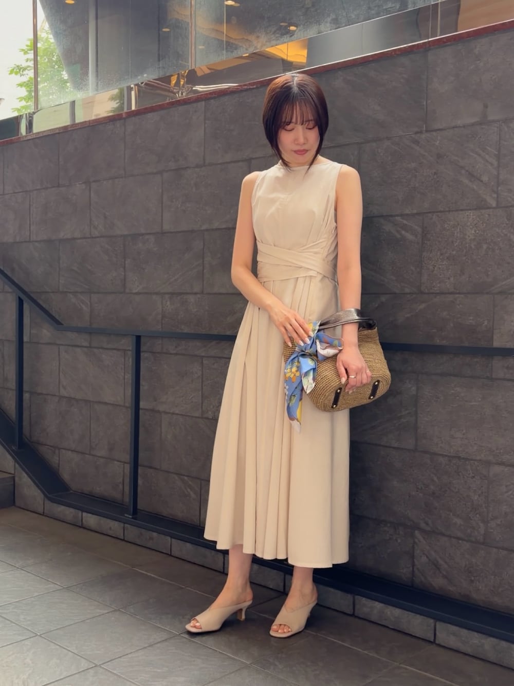 ホワイト系のワンピース、ブラウン系のかごバッグ、ホワイト系のパンプスを着用したレディースの夏コーディネートの3枚目の写真