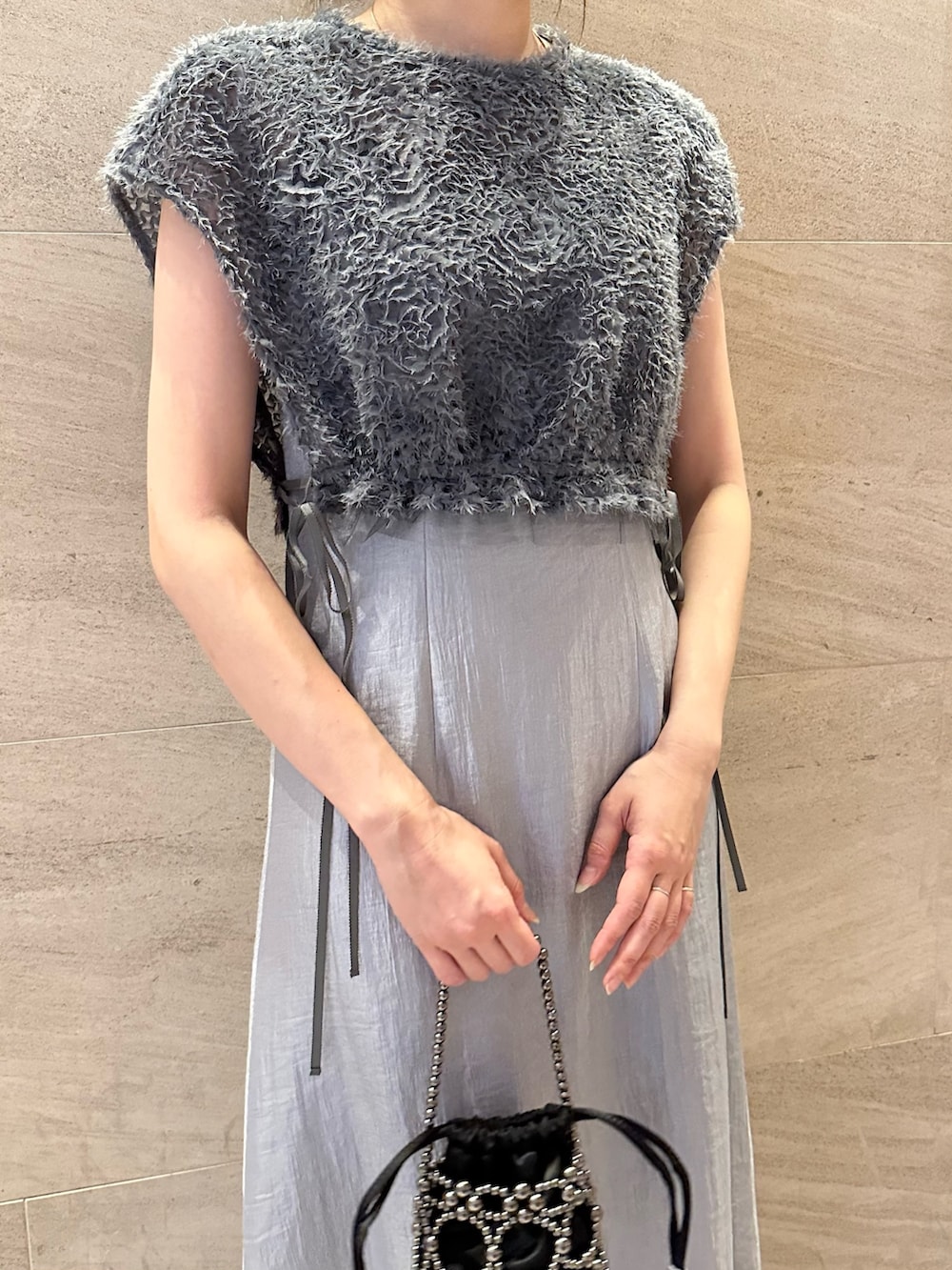 ブルー系のワンピース、ブラック系のハンドバッグ、ブラック系のパンプスを着用したレディースの夏コーディネートの6枚目の写真