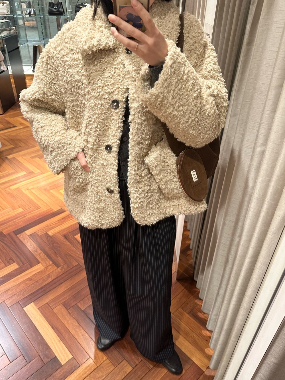 ホワイト系のその他アウター、ブラウン系のトートバッグ、その他のその他パンツを着用したレディースの冬コーディネートの3枚目の写真