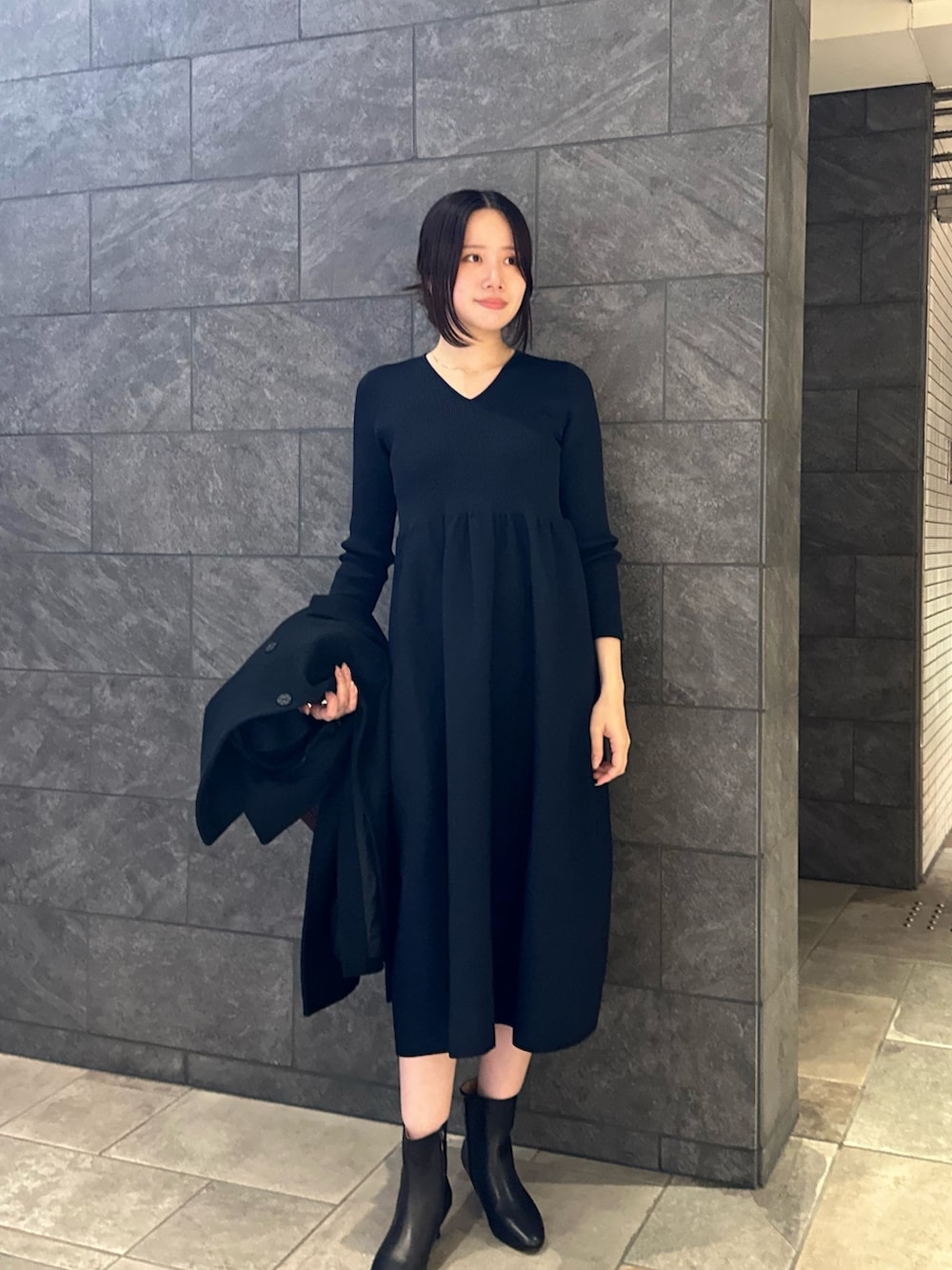 ブルー系のワンピース、ブラック系のその他アウター、ブラウン系のショルダーバッグを着用したレディースの秋コーディネートの6枚目の写真