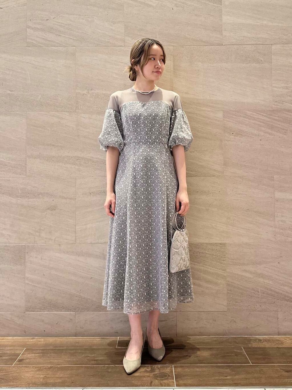 ブラウン系のパンプス、シルバー系のハンドバッグ、グレー系のワンピースを着用したレディースの春コーディネートの2枚目の写真