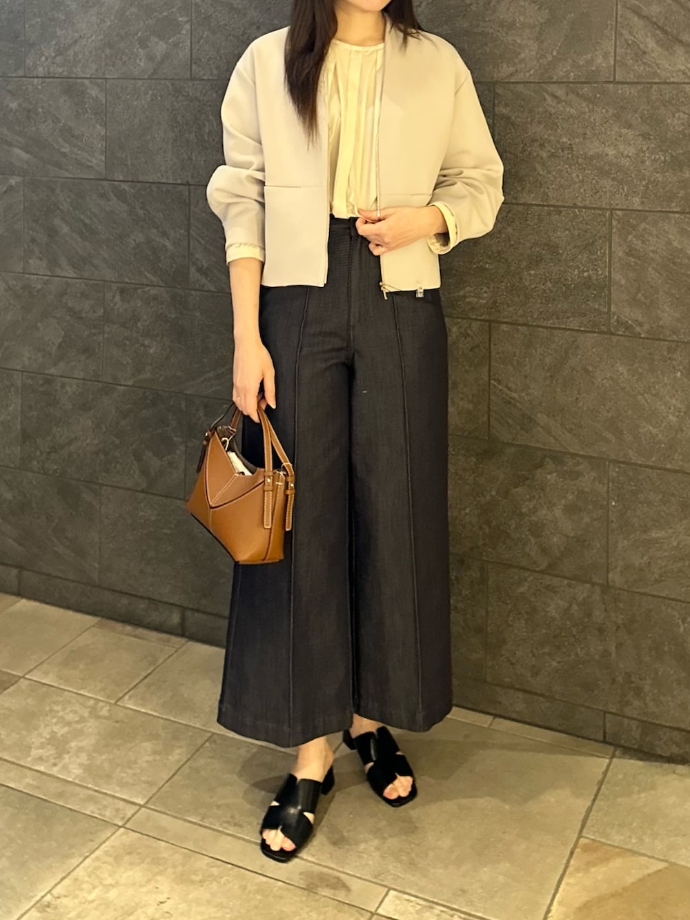 グレー系のブルゾン、イエロー系のシャツ/ブラウス、ブルー系のデニムパンツを着用したレディースの春コーディネートの3枚目の写真