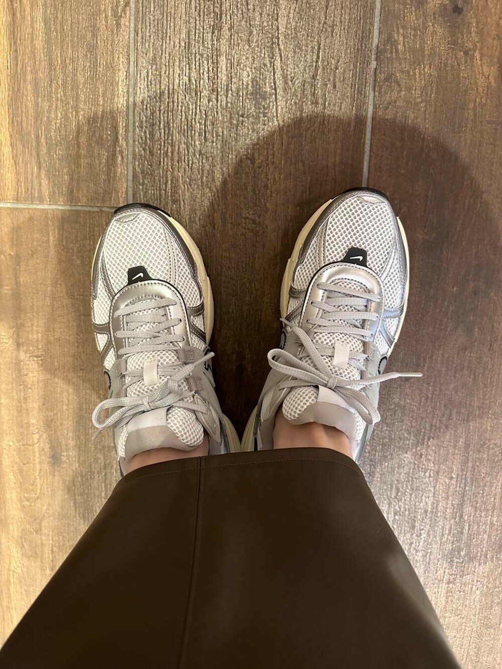 ブラウン系のスカート、イエロー系のダウンジャケット/コート、ホワイト系のスニーカーを着用したレディースの冬コーディネートの7枚目の写真