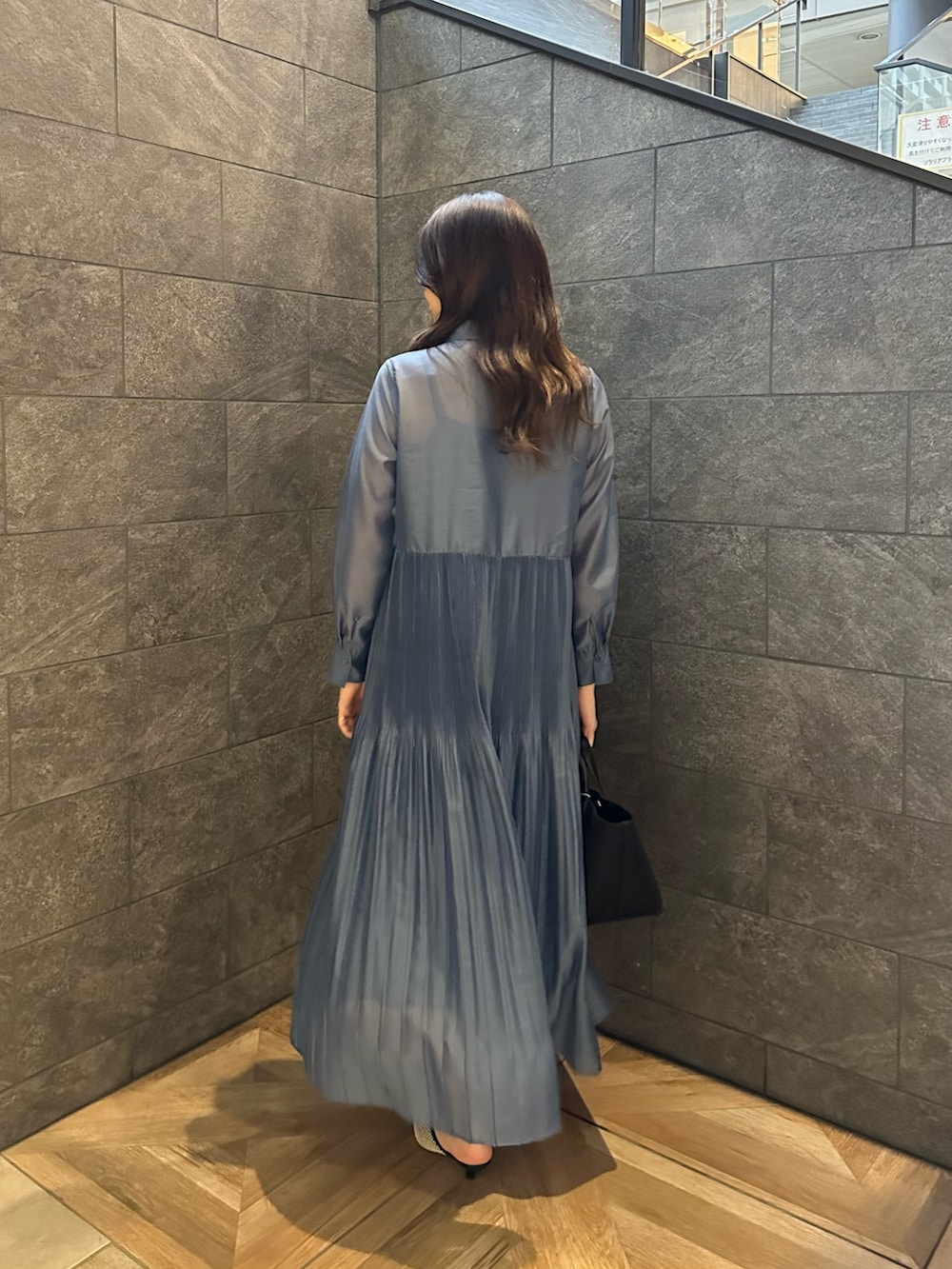 ブルー系のワンピース、ブラック系のパンプスを着用したレディースの冬コーディネートの5枚目の写真