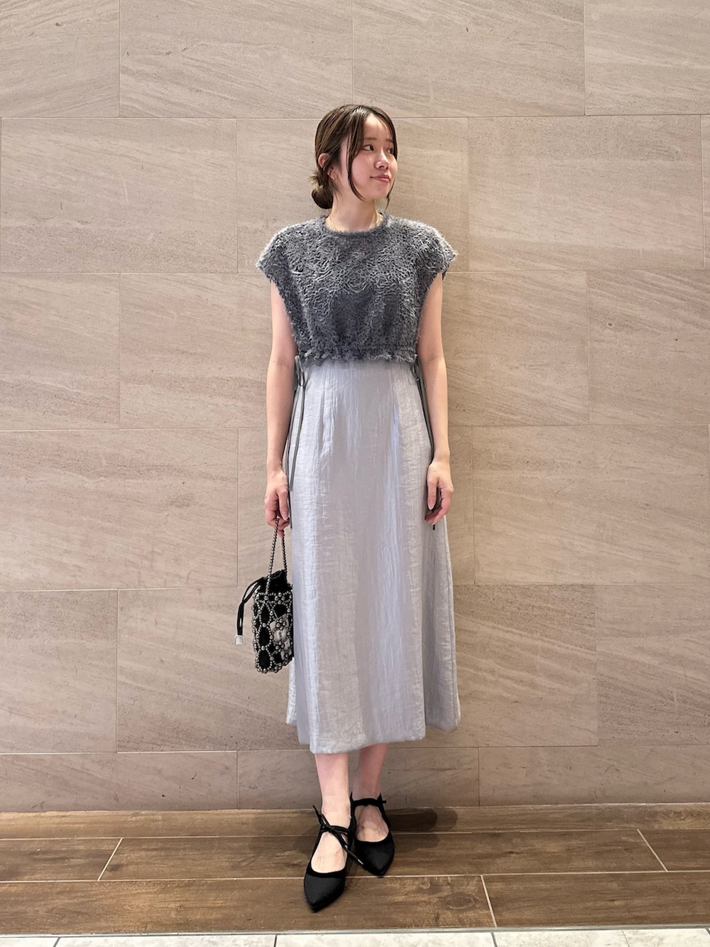 ブルー系のワンピース、ブラック系のハンドバッグ、ブラック系のパンプスを着用したレディースの夏コーディネートの3枚目の写真