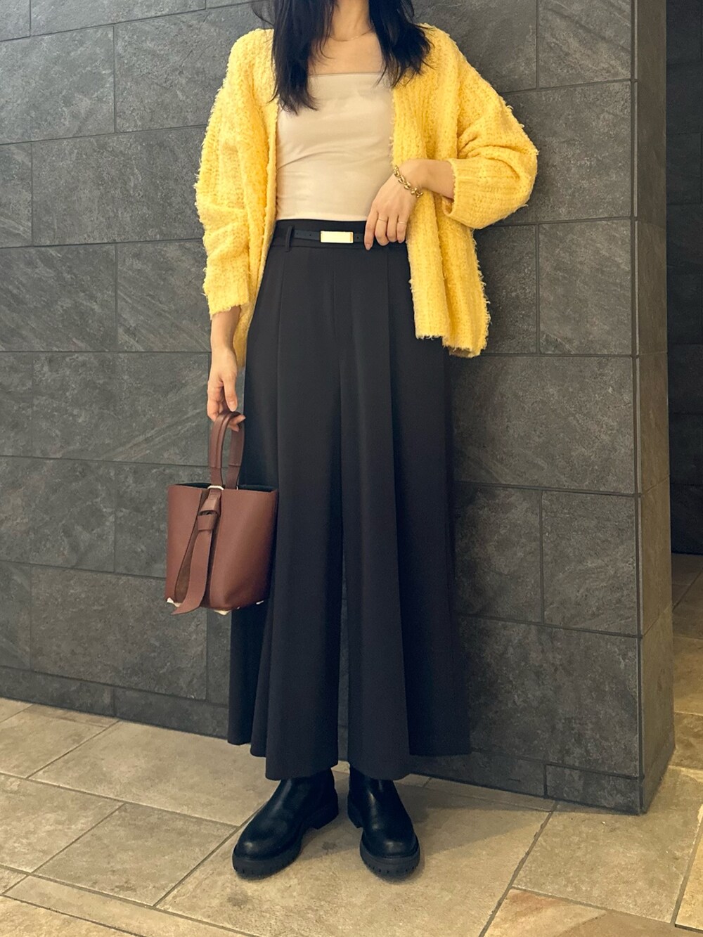 イエロー系のカーディガン/ボレロ、グレー系のその他パンツ、ベージュ系のキャミソールを着用したレディースの秋コーディネートの3枚目の写真