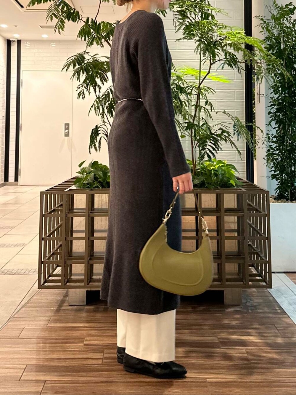 グリーン系のショルダーバッグ、グレー系のワンピース、ホワイト系のその他パンツを着用したレディースの冬コーディネートの4枚目の写真