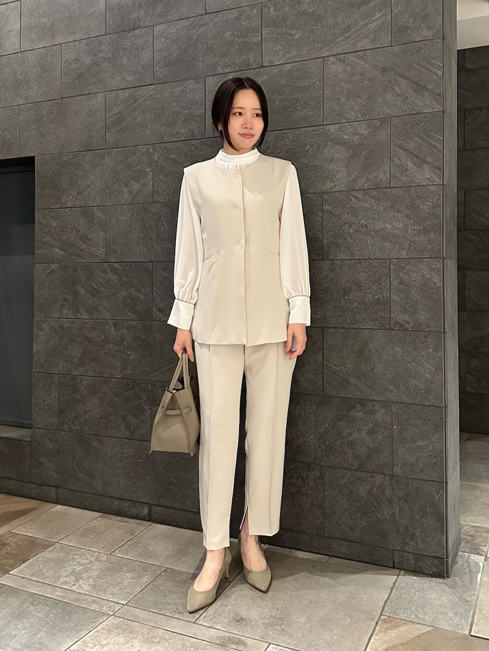 ホワイト系のセットアップ、ベージュ系のトートバッグ、ブラウン系のその他アウターを着用したレディースの冬コーディネートの2枚目の写真