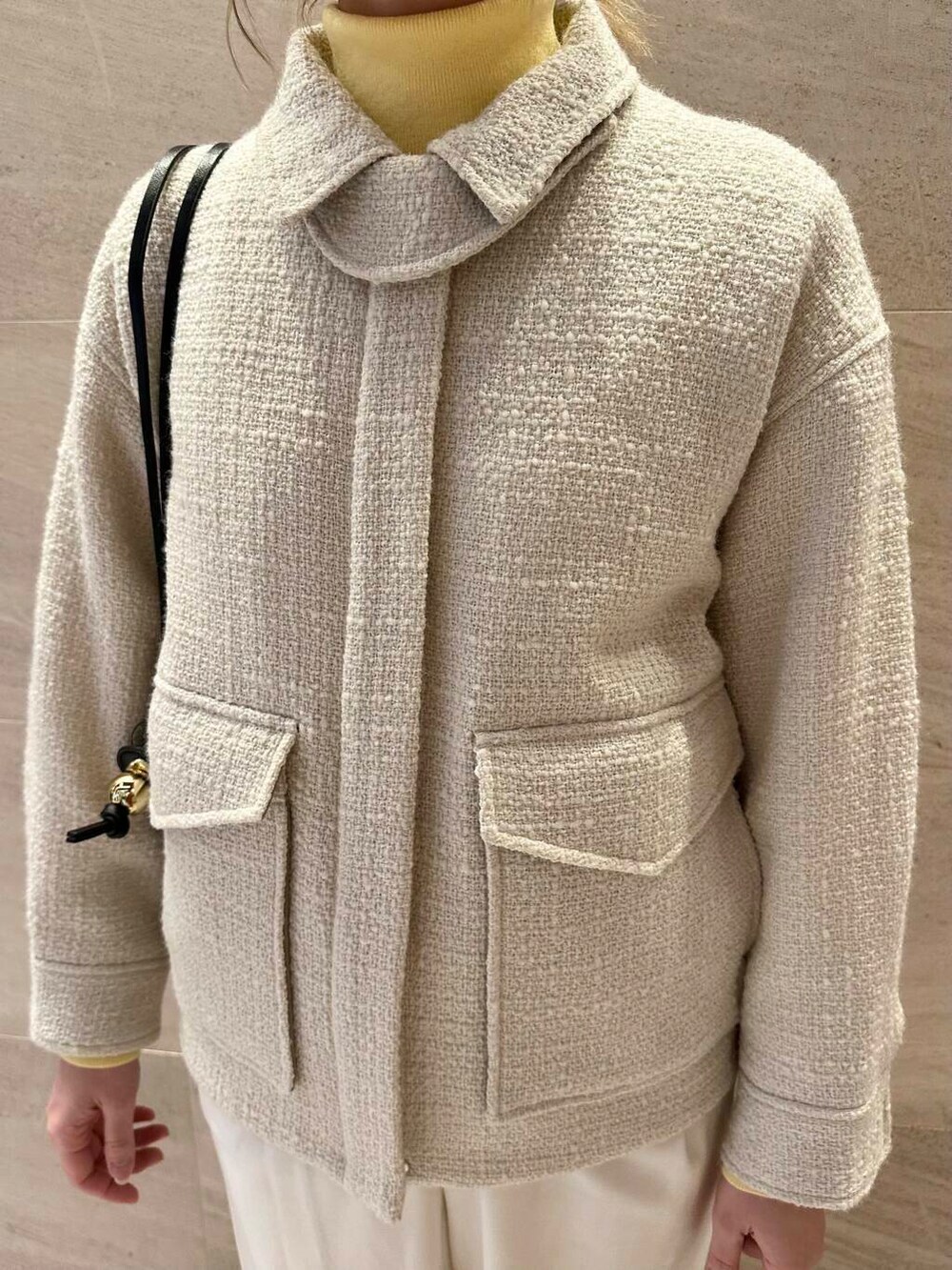 ホワイト系のスニーカー、ホワイト系のブルゾン、ブラック系のショルダーバッグを着用したレディースの冬コーディネートの6枚目の写真