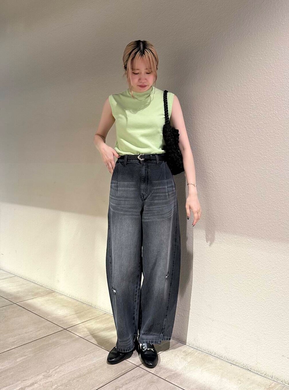 ブラック系のローファー、グリーン系のニット/セーター、グレー系のデニムパンツを着用したレディースの夏コーディネートの2枚目の写真