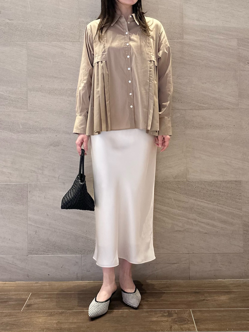 ベージュ系のシャツ/ブラウス、ホワイト系のスカート、ブラック系のトートバッグを着用したレディースの春コーディネートの3枚目の写真