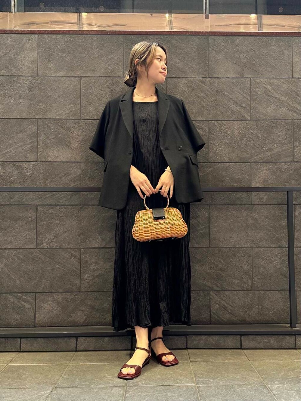 レッド系のサンダル、ブラック系のワンピース、ブラック系のその他アウターを着用したレディースの春コーディネートの2枚目の写真