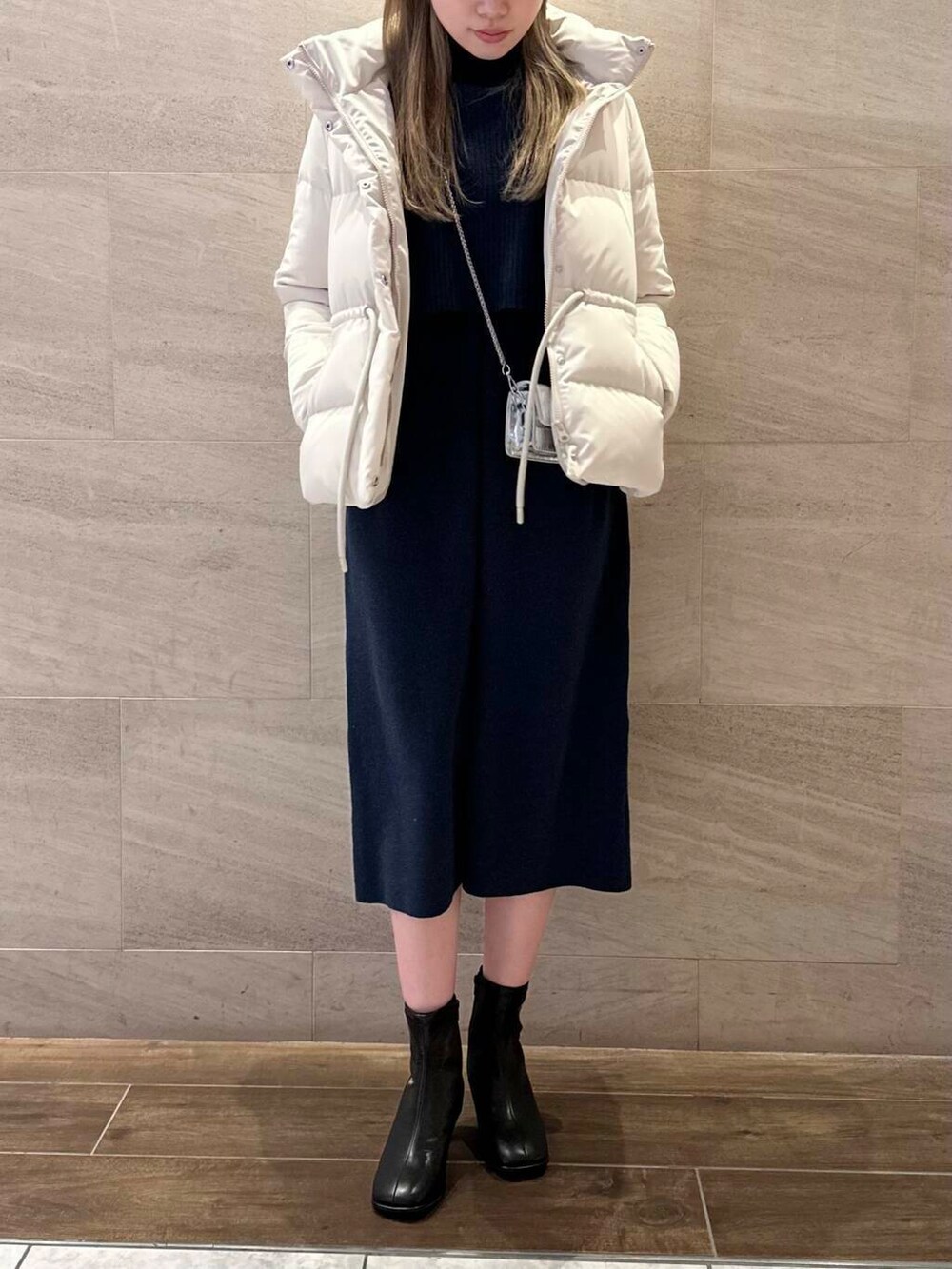 ブラック系のブーツ、ホワイト系のダウンジャケット/コート、ブルー系のワンピースを着用したレディースの冬コーディネートの6枚目の写真
