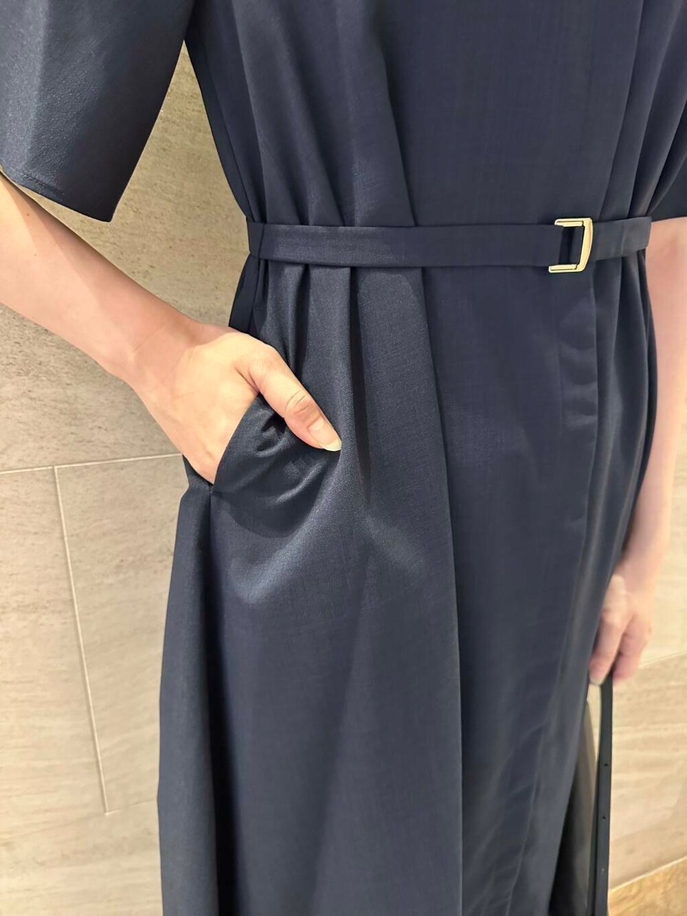 ブラック系のパンプス、ブルー系のワンピース、ブラック系のショルダーバッグを着用したレディースの夏コーディネートの5枚目の写真