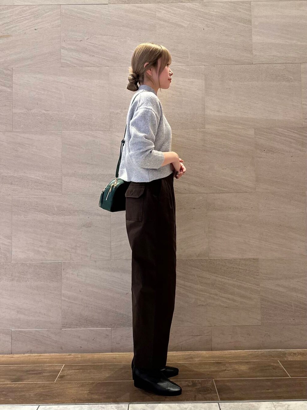 ブラック系のブーツ、グリーン系のショルダーバッグ、グレー系のニット/セーターを着用したレディースの秋コーディネートの5枚目の写真