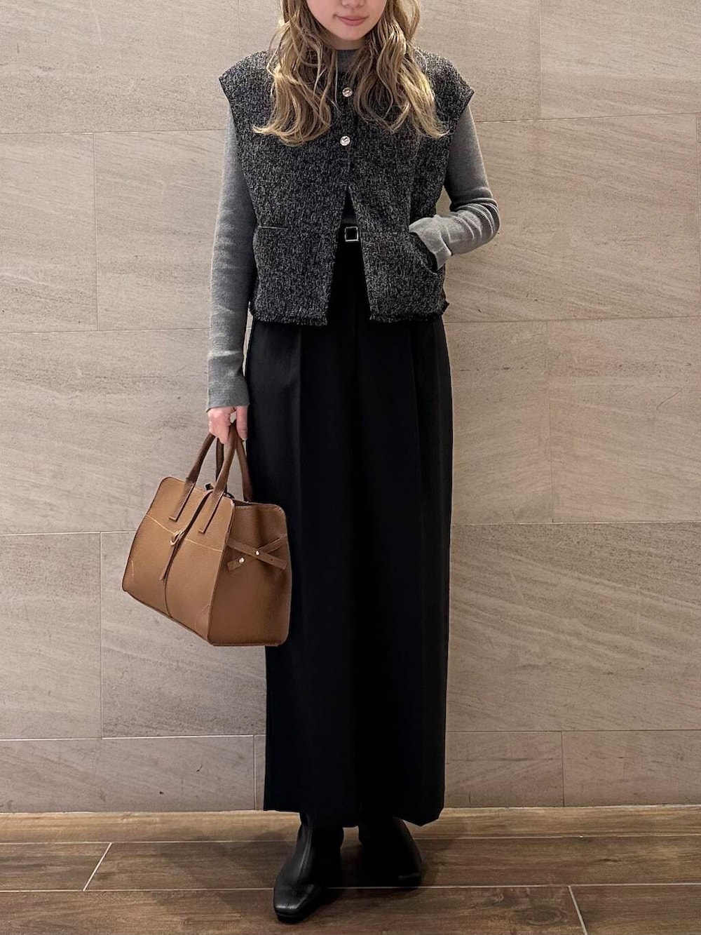ブラウン系のハンドバッグ、グレー系のニット/セーター、ブラック系のその他パンツを着用したレディースの冬コーディネートの6枚目の写真