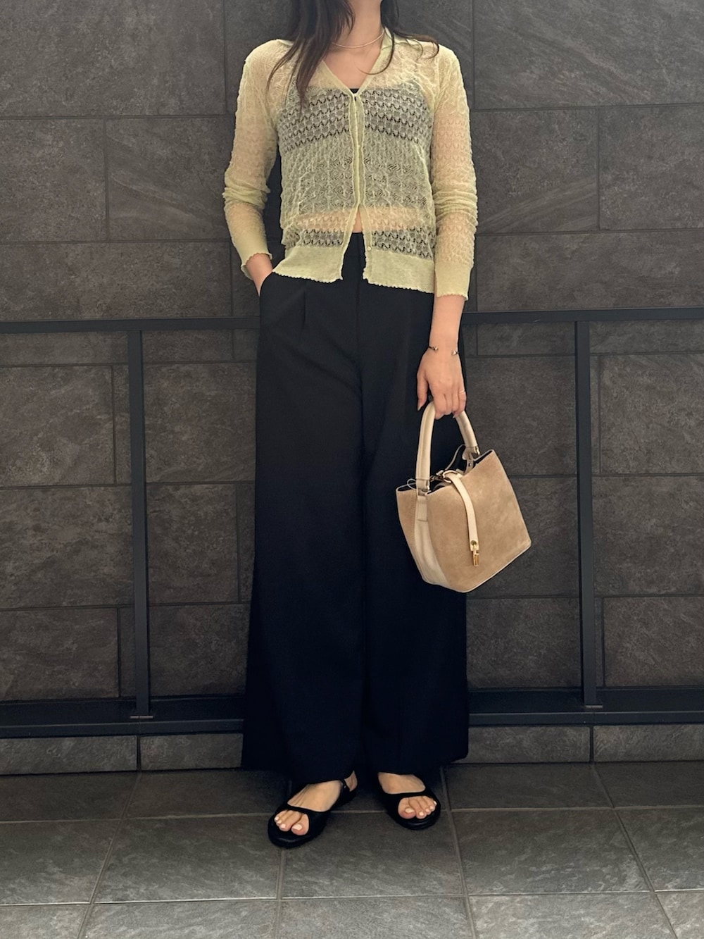 グリーン系のカーディガン/ボレロ、ブラック系のその他パンツ、ベージュ系のハンドバッグを着用したレディースの春コーディネートの3枚目の写真