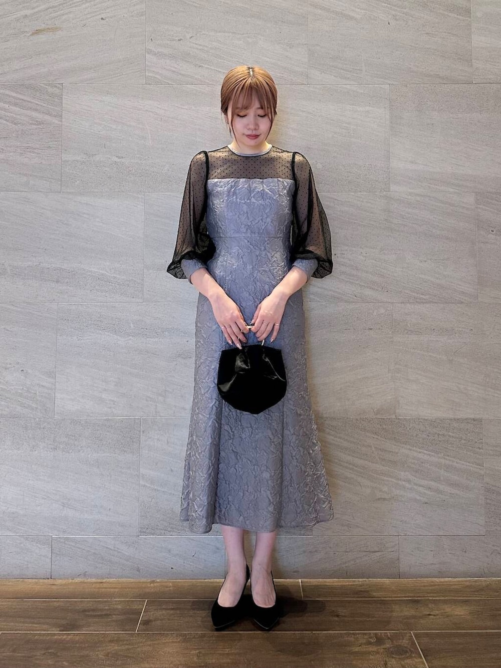 ブラック系のパンプス、ブラック系のハンドバッグ、グレー系のワンピースを着用したレディースの夏コーディネートの5枚目の写真