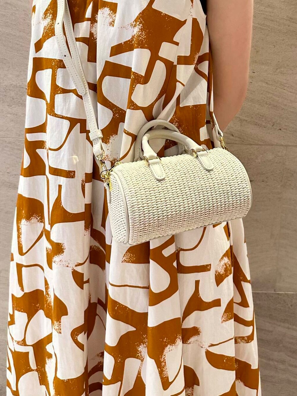 ホワイト系のサンダル、オレンジ系のワンピースを着用したレディースの春コーディネートの6枚目の写真