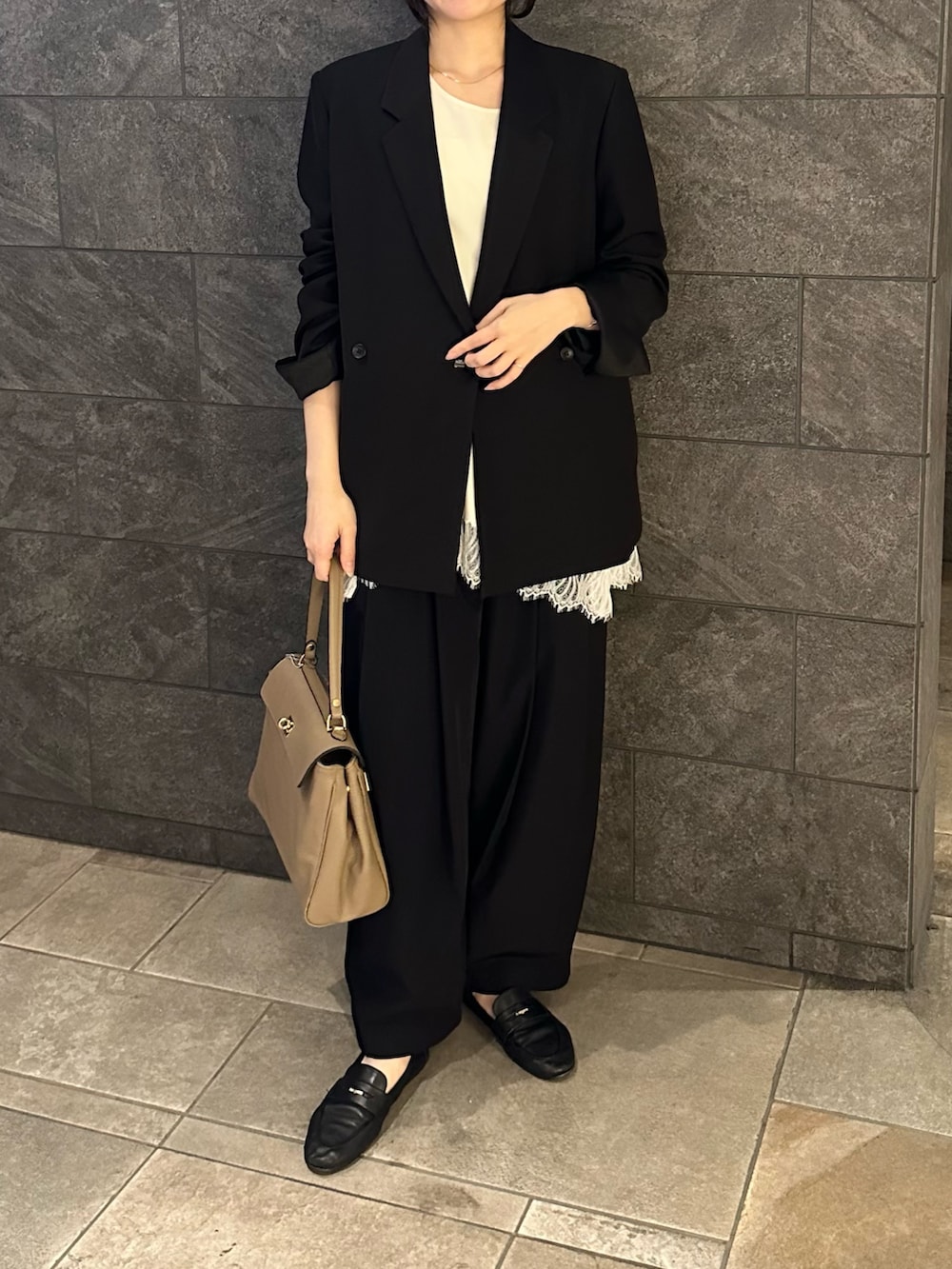 ベージュ系のハンドバッグ、ブラック系のその他パンツ、ホワイト系のタンクトップを着用したレディースの春コーディネートの2枚目の写真