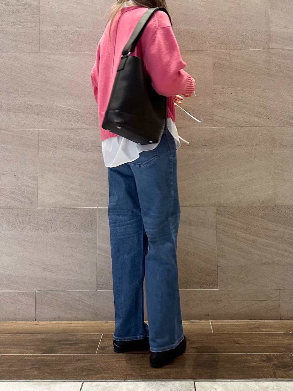 ピンク系のニット/セーター、ホワイト系のシャツ/ブラウス、ブラック系のショルダーバッグを着用したレディースの冬コーディネートの4枚目の写真