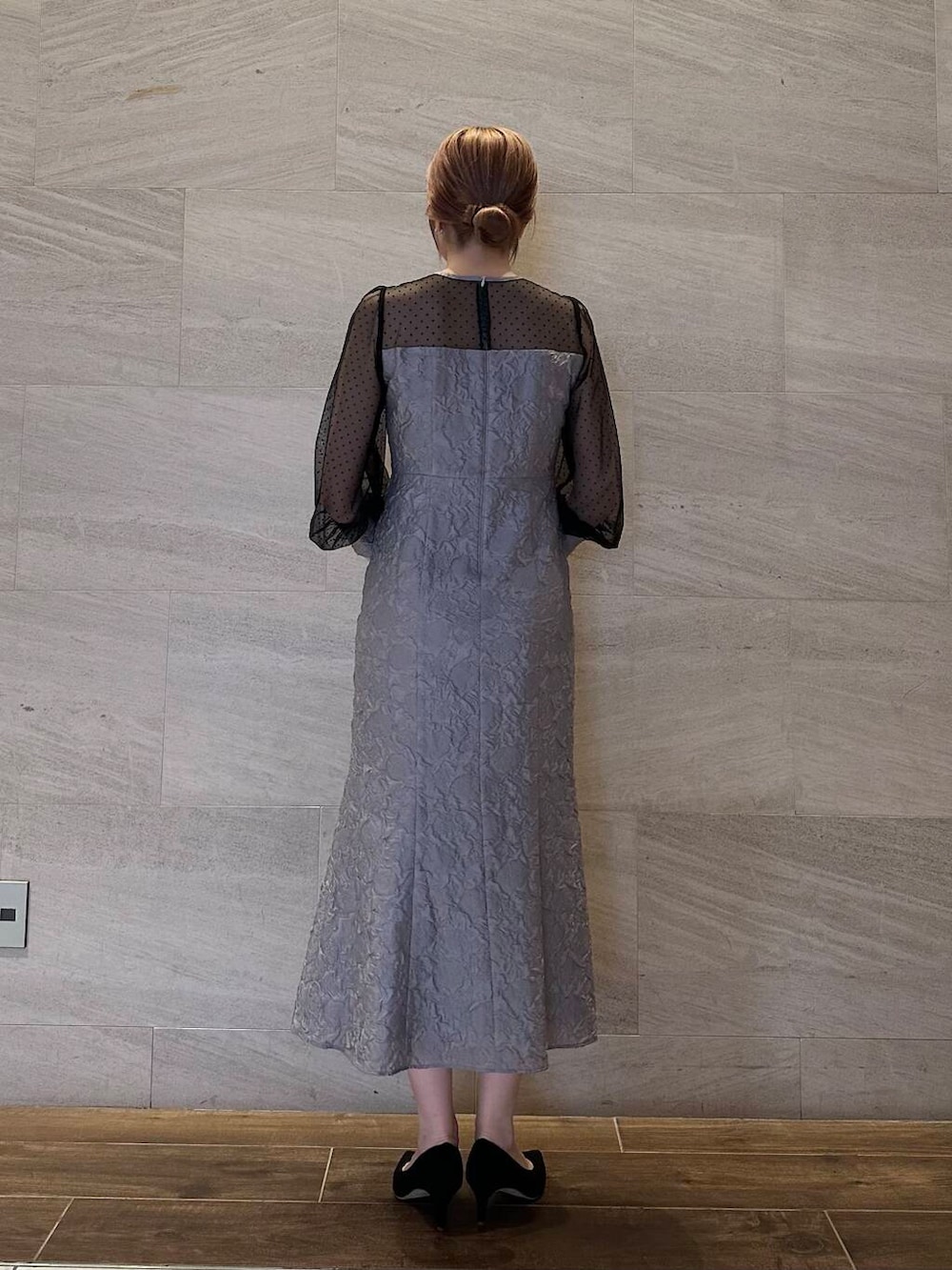 ブラック系のパンプス、ブラック系のハンドバッグ、グレー系のワンピースを着用したレディースの夏コーディネートの6枚目の写真