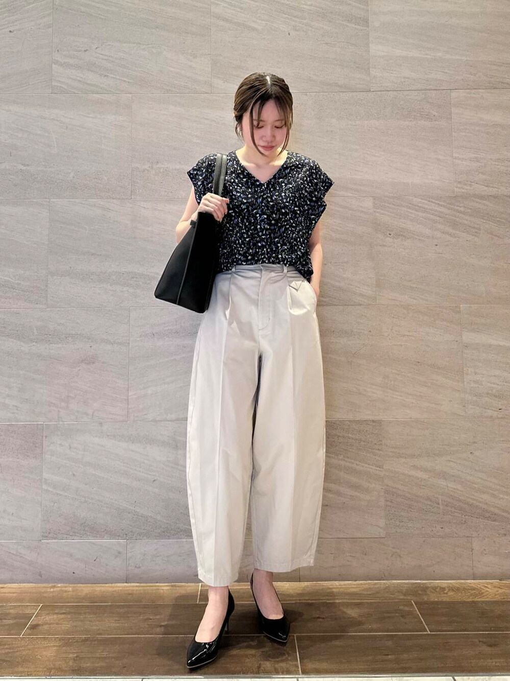 ブラック系のパンプス、ブラック系のシャツ/ブラウス、ベージュ系のその他パンツを着用したレディースの夏コーディネートの4枚目の写真