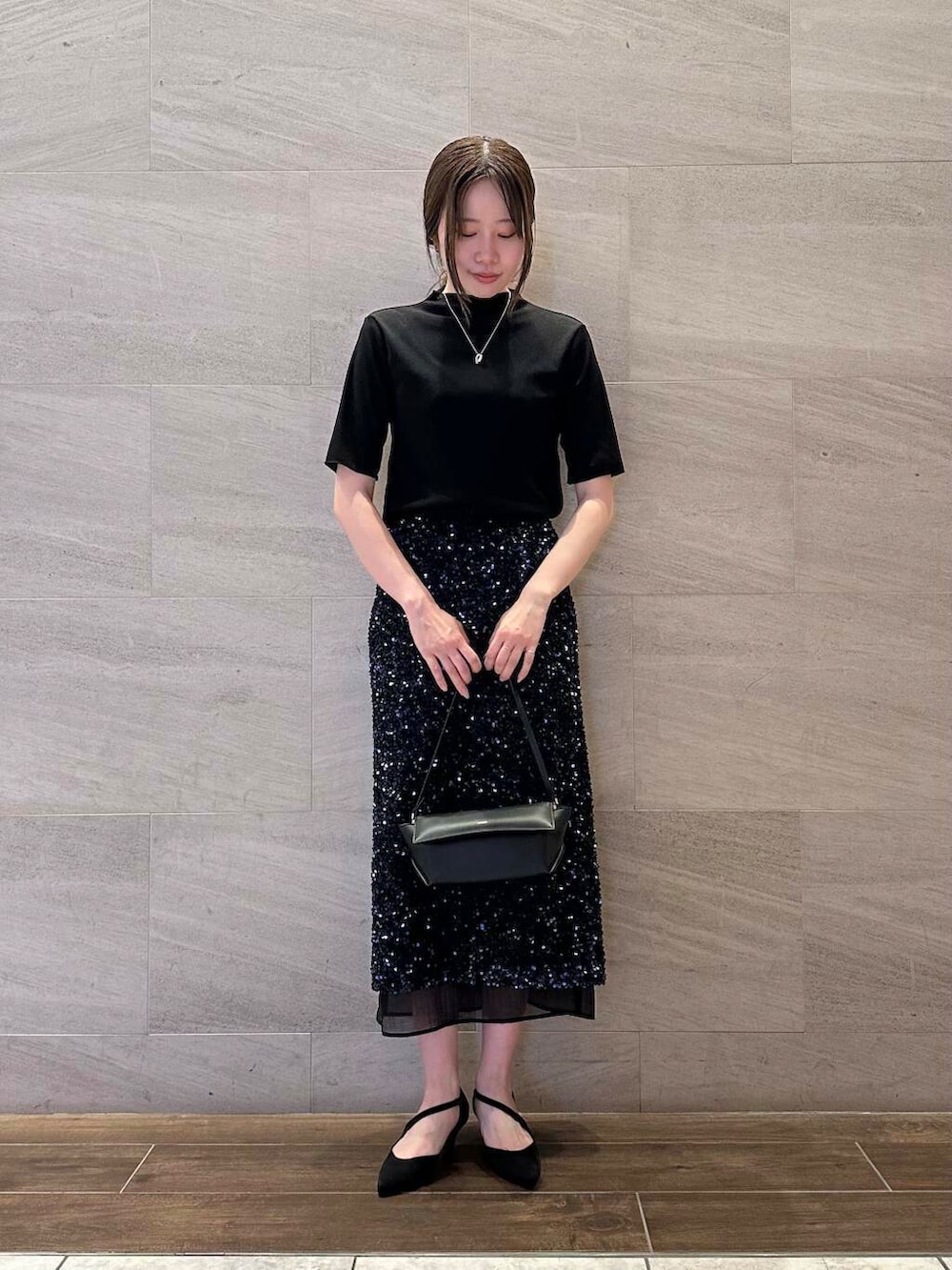 ブルー系のスカート、ブラック系のTシャツ/カットソー、シルバー系のネックレスを着用したレディースの夏コーディネートの2枚目の写真