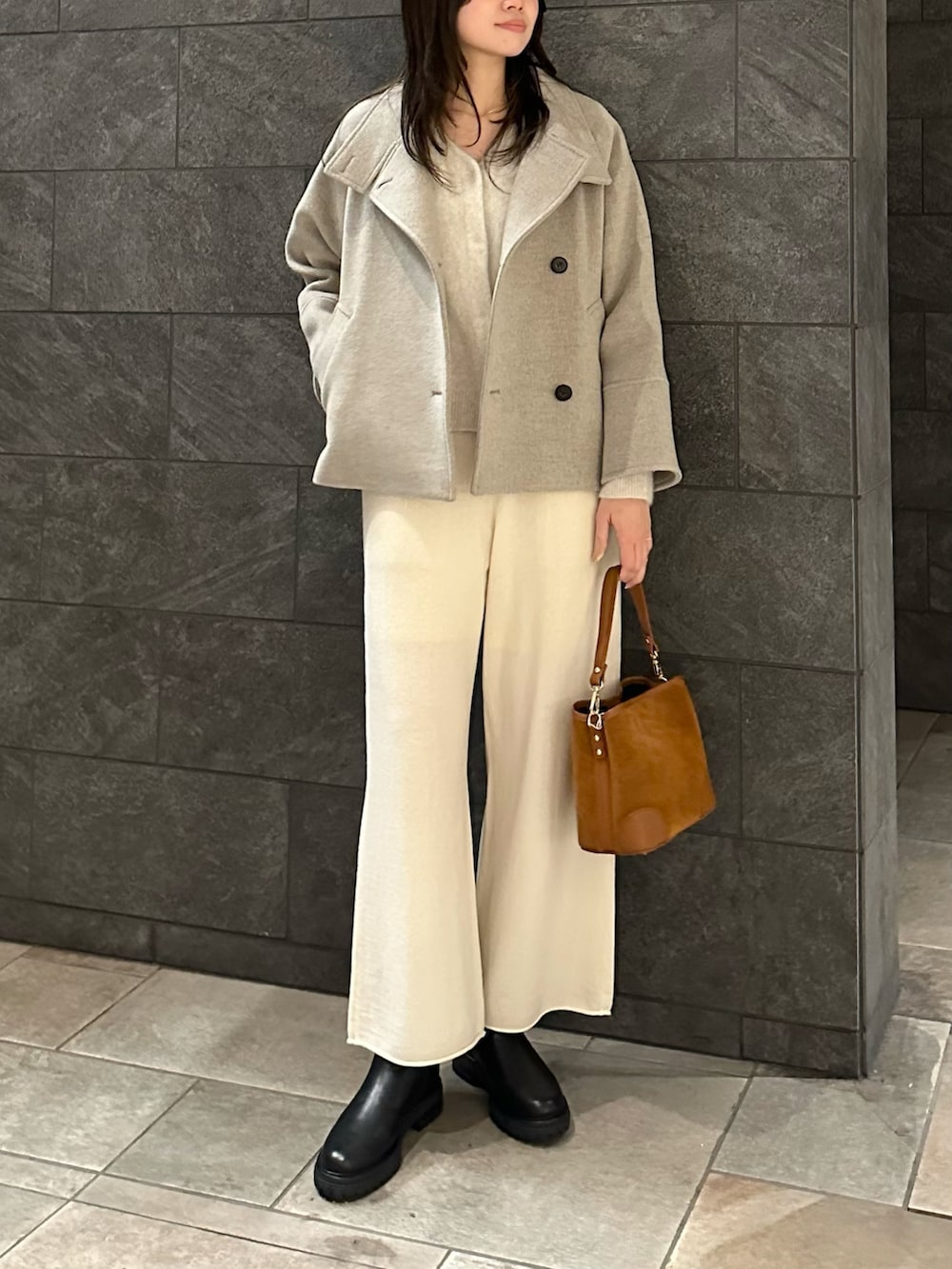 ホワイト系のカーディガン/ボレロ、ホワイト系のその他パンツ、ブラウン系のハンドバッグを着用したレディースの冬コーディネートの4枚目の写真