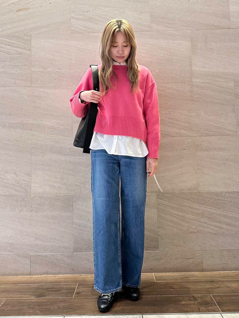 ピンク系のニット/セーター、ホワイト系のシャツ/ブラウス、ブラック系のショルダーバッグを着用したレディースの冬コーディネートの2枚目の写真