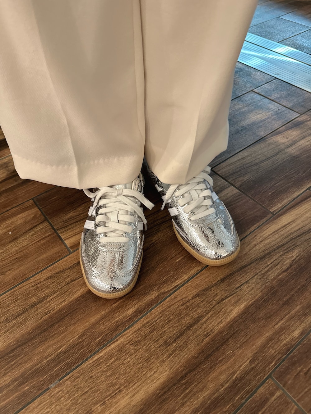 ベージュ系のトレンチコート、ホワイト系のTシャツ/カットソー、ブラック系のショルダーバッグを着用したレディースの春コーディネートの6枚目の写真