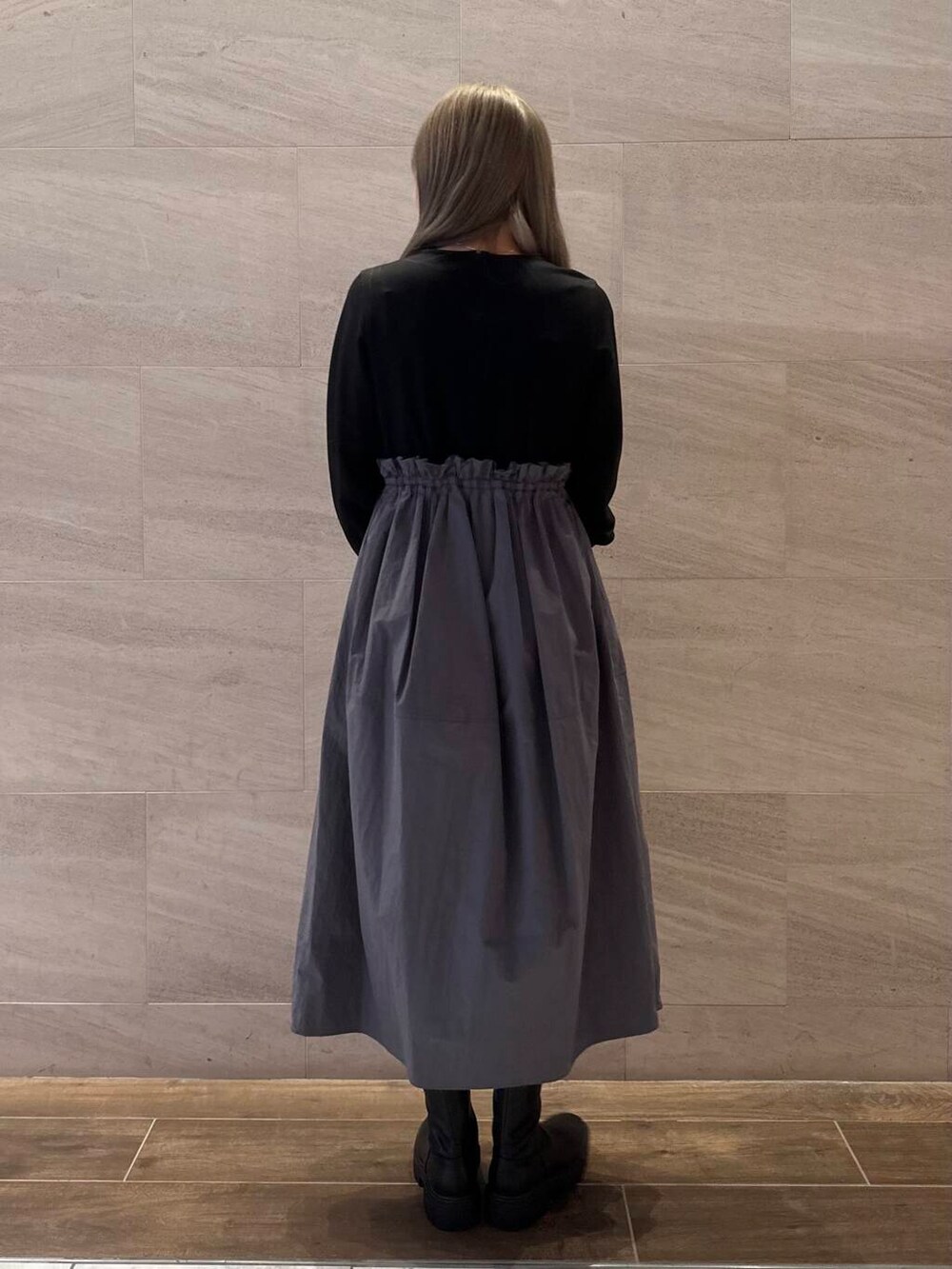 ブラック系のブーツ、ブラック系のワンピース、レッド系のハンドバッグを着用したレディースの冬コーディネートの5枚目の写真