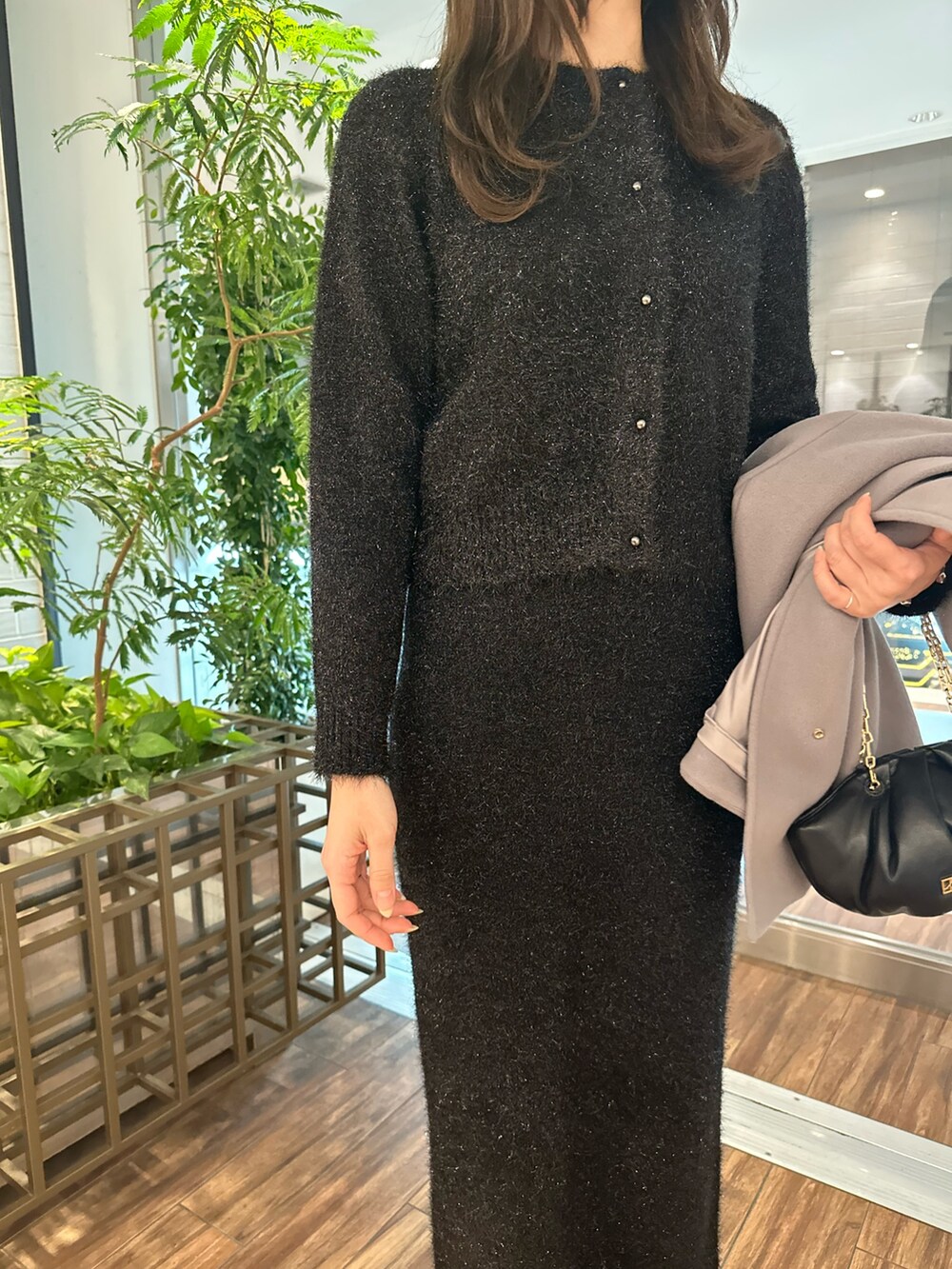 ブラック系のカーディガン/ボレロ、ブラック系のスカート、ベージュ系のその他アウターを着用したレディースの冬コーディネートの3枚目の写真