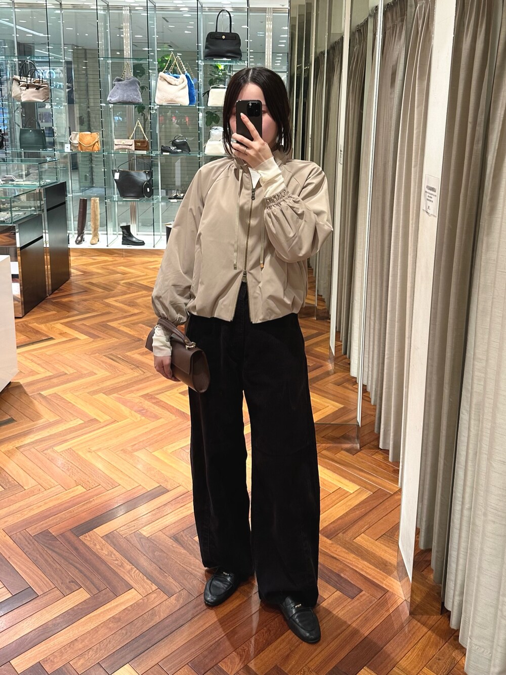 ベージュ系のブルゾン、グレー系のその他パンツ、ホワイト系のTシャツ/カットソーを着用したレディースの秋コーディネートの2枚目の写真